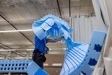 Une fois que la machine a découpé les motifs, un employé enlève les restes.