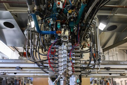 Une machine digne H.R. Giger injecte la pâte du gâteau en mousse sur une bande.